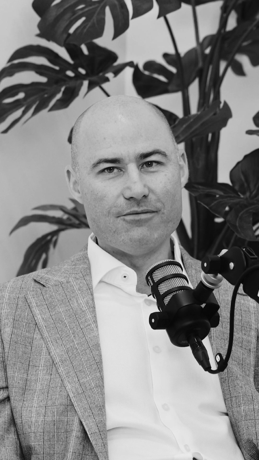 Credibility Clips interview in progress at Content Hype's Essendon studio — Rode PodMic on boom arm, monstera backdrop, B&W finish